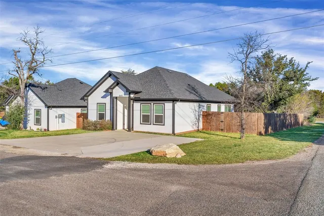 a view of a house with a yard and potted plants
