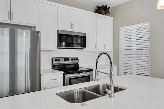 a kitchen with a sink cabinets and stainless steel appliances