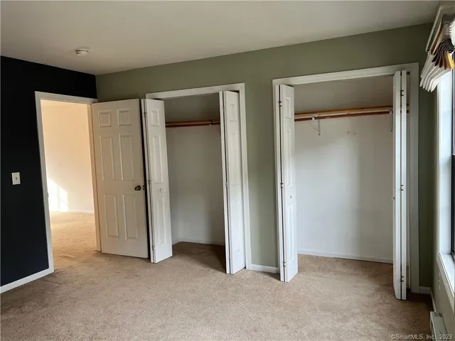 an empty room with closet and a bathroom