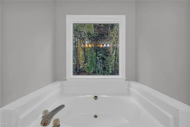 a bathroom with bathtub and window