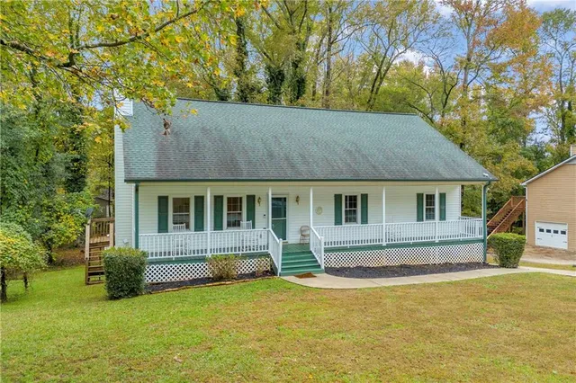 a front view of house with yard and trees in the background