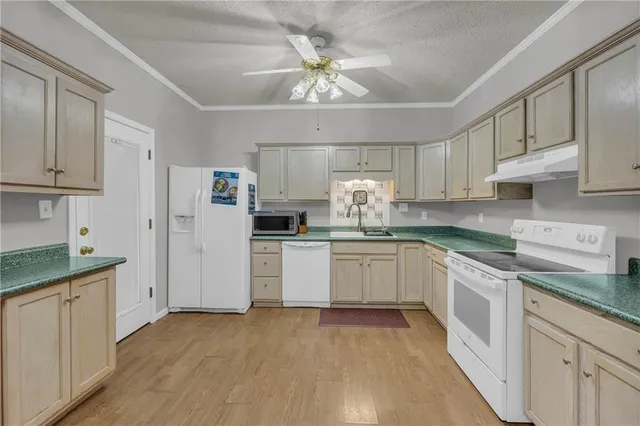 a kitchen with granite countertop white cabinets and white appliances
