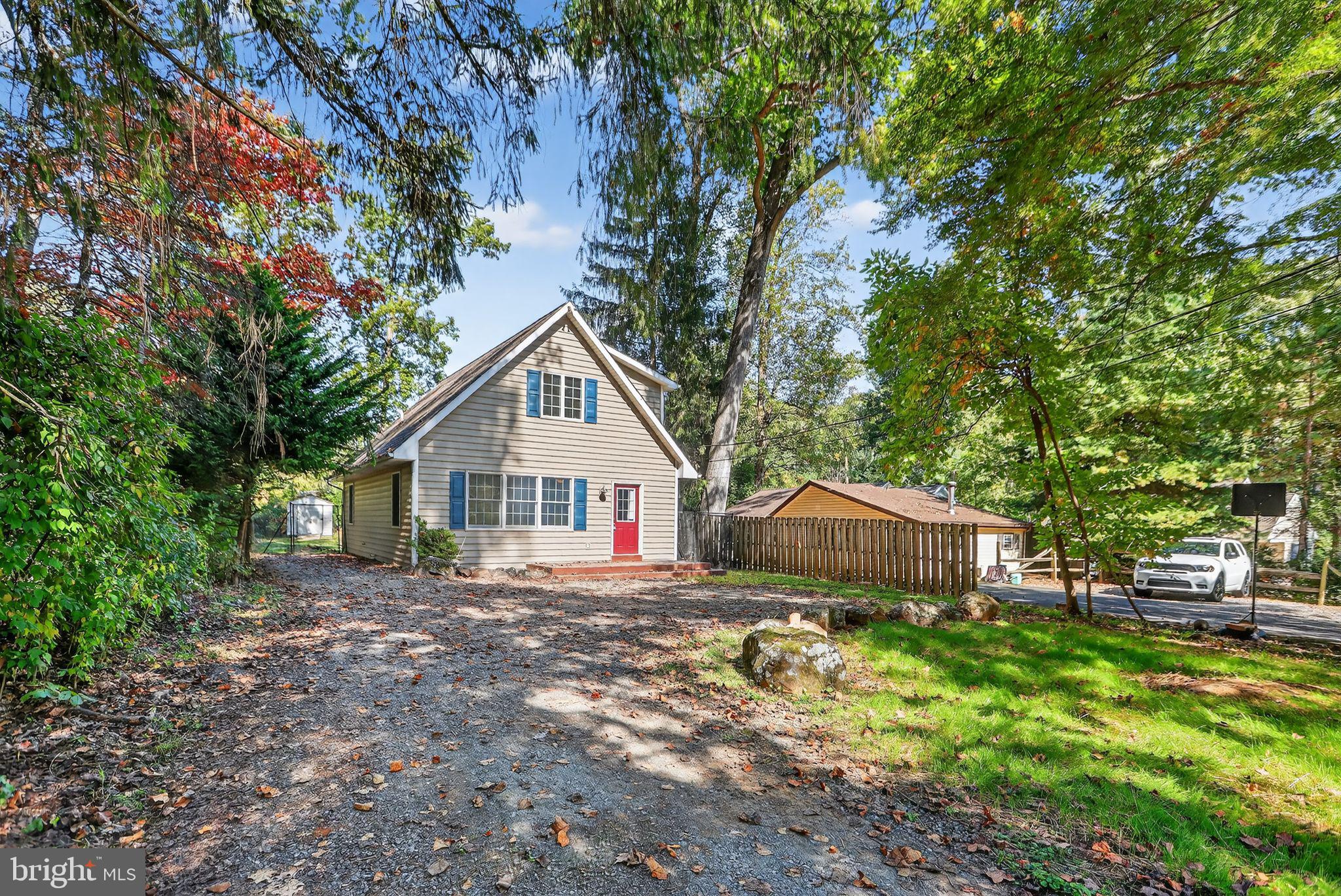 a front view of a house with a garden and trees