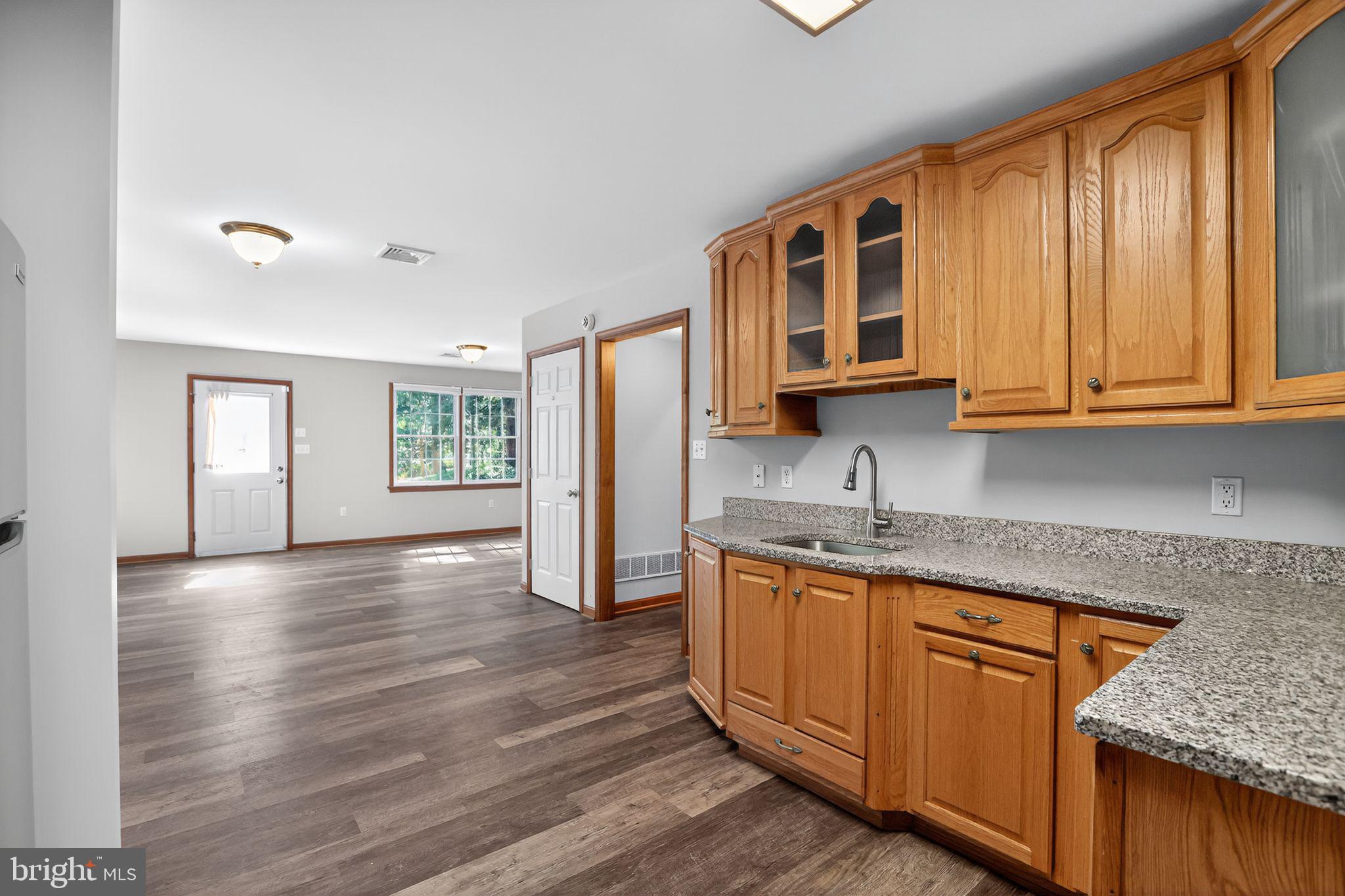 1709 Snyder Road Green Lane, PA 18054 - Photo 6 of 30 a kitchen with stainless steel appliances granite countertop wooden cabinets a sink and dishwasher with wooden floor