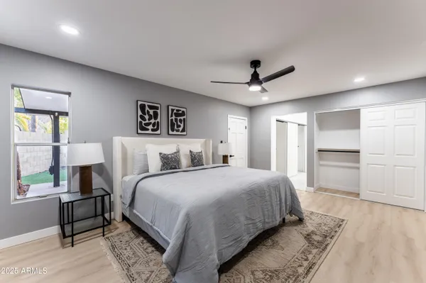a spacious bedroom with a bed and a ceiling fan
