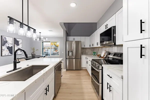 a kitchen with stainless steel appliances granite countertop a sink and stove top oven