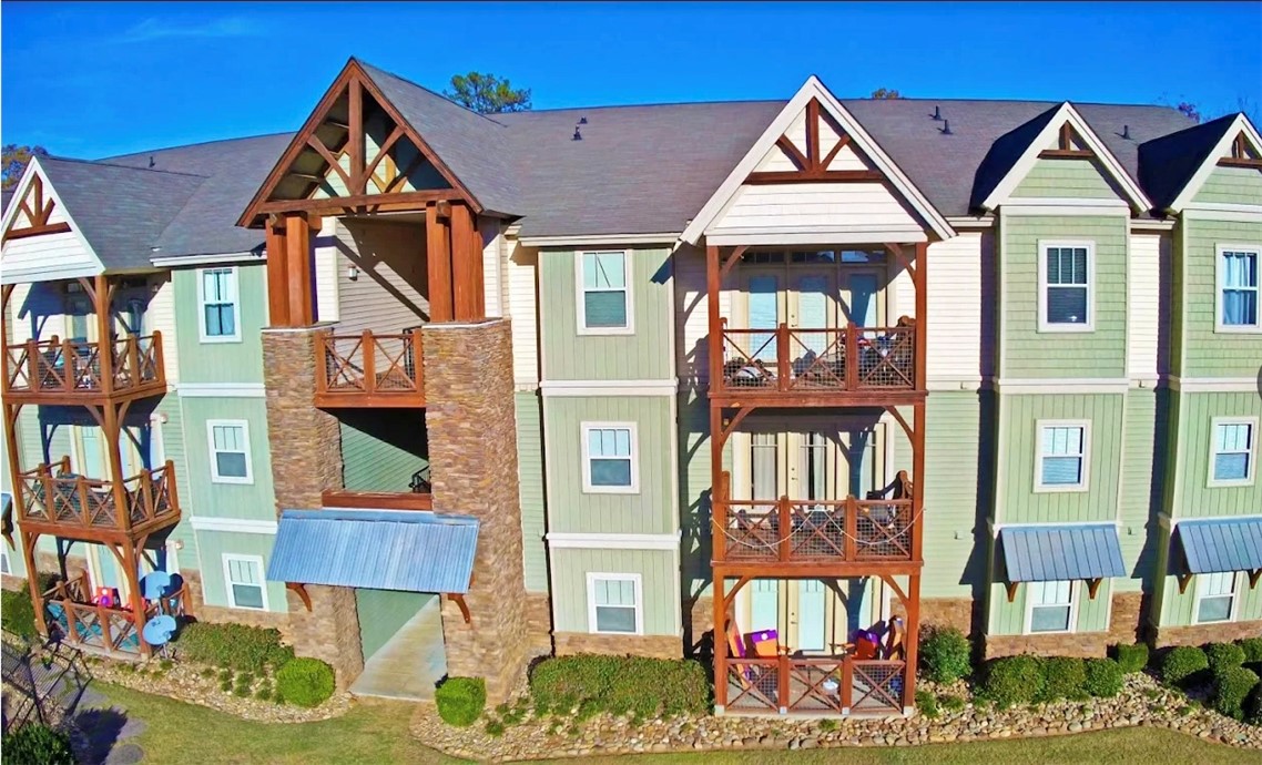 This charming multi-story residence features inviting balconies and an appealing blend of siding and stone.