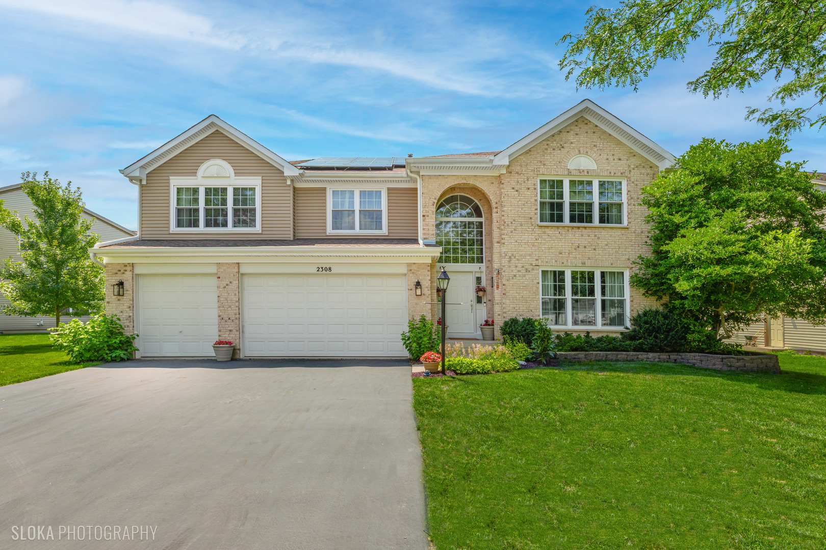 a view of a house with a yard and potted plants