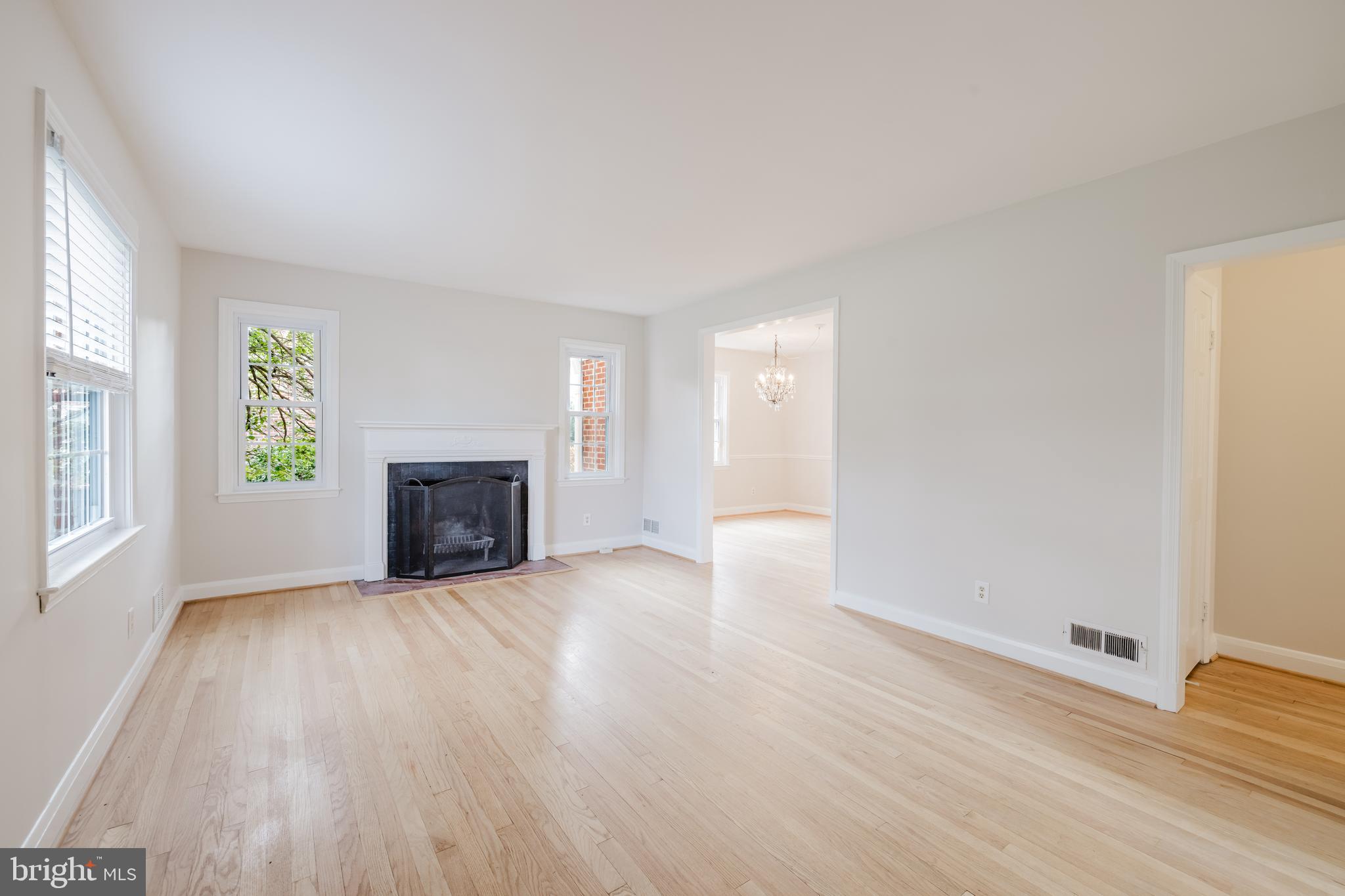 904 Locustvale Road Towson, MD 21204 - Photo 3 of 29 an empty room with wooden floor fireplace and windows