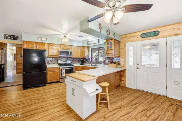 a open kitchen with stainless steel appliances granite countertop a lot of counter space and wooden floors