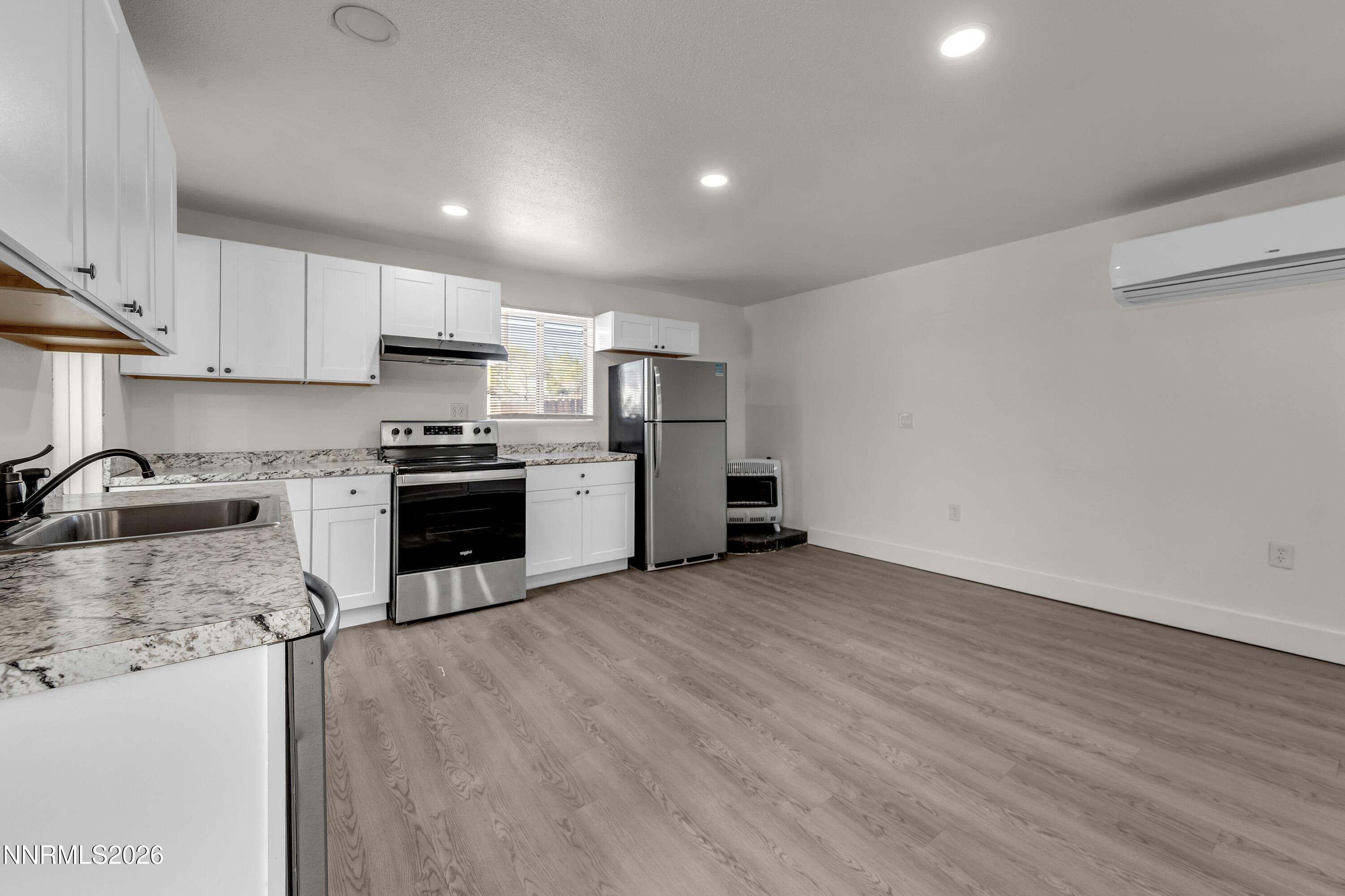 1939 Wilder Street Reno, NV 89512 - Photo 23 of 28 a kitchen with stainless steel appliances granite countertop a stove top oven a sink dishwasher and a refrigerator with wooden floor