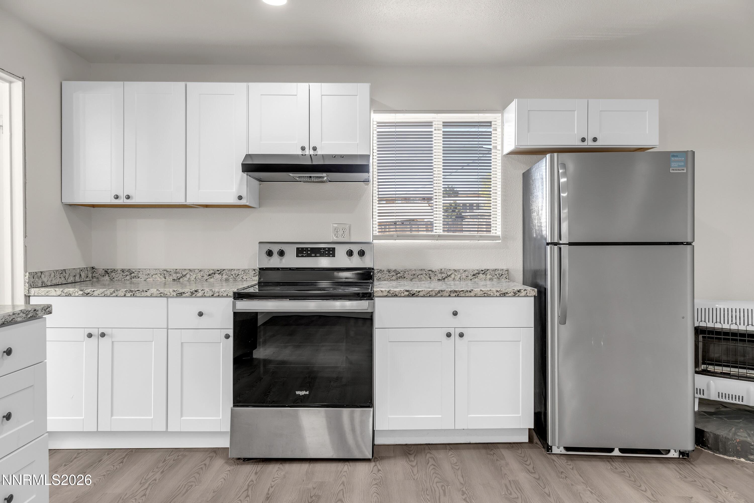 1939 Wilder Street Reno, NV 89512 - Photo 24 of 28 a kitchen with granite countertop white cabinets and stainless steel appliances