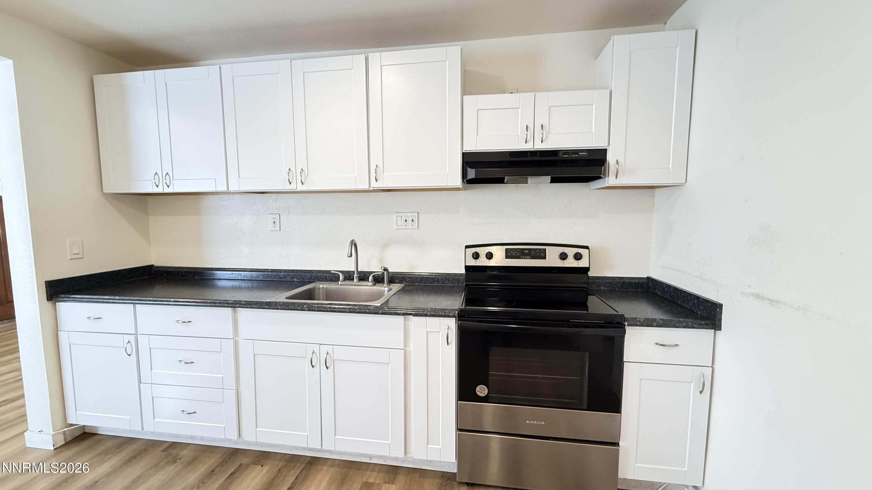 1939 Wilder Street Reno, NV 89512 - Photo 7 of 28 a kitchen with granite countertop white cabinets and stainless steel appliances