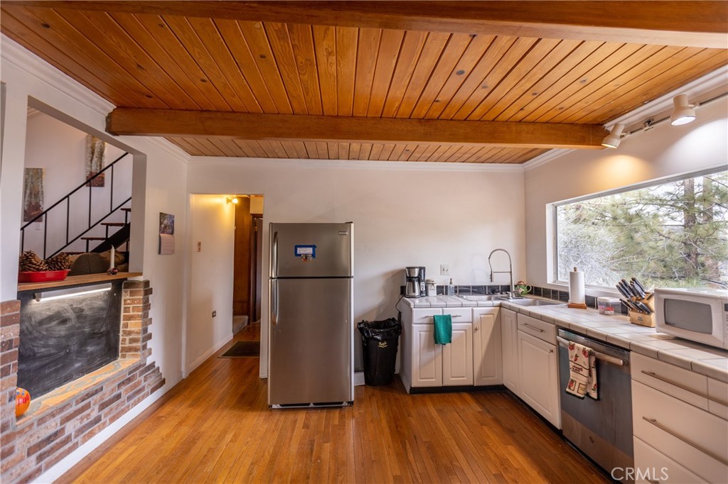 5218 Desert View Drive Wrightwood, CA 92397 - Photo 18 of 50 a kitchen with a sink a refrigerator and wooden floor