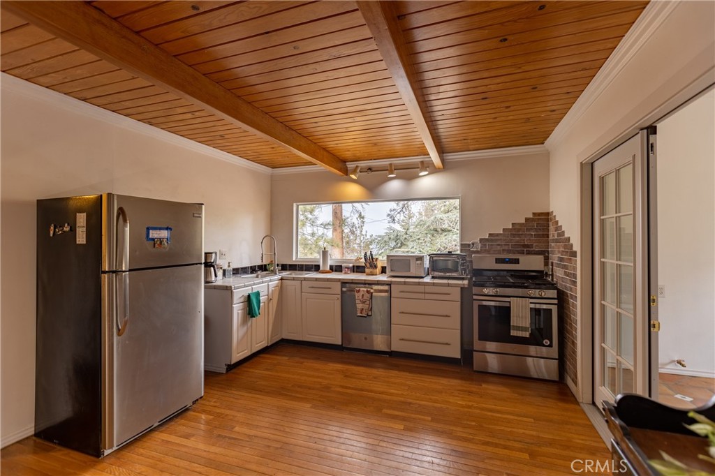 5218 Desert View Drive Wrightwood, CA 92397 - Photo 10 of 50 a kitchen with a refrigerator wooden floor and stainless steel appliances