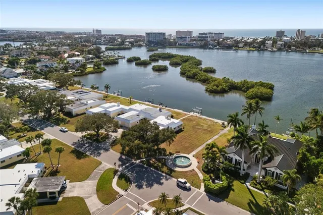 an aerial view of residential houses with outdoor space and lake view