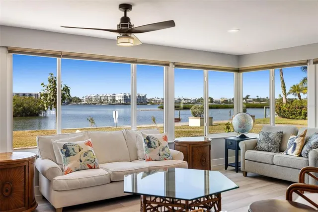 a living room with furniture a chandelier and a floor to ceiling window
