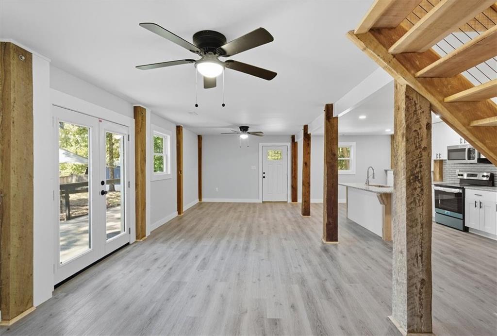96 Collins Road Rome, GA 30161 - Photo 15 of 57 a view of a big room with wooden floor a ceiling fan and windows