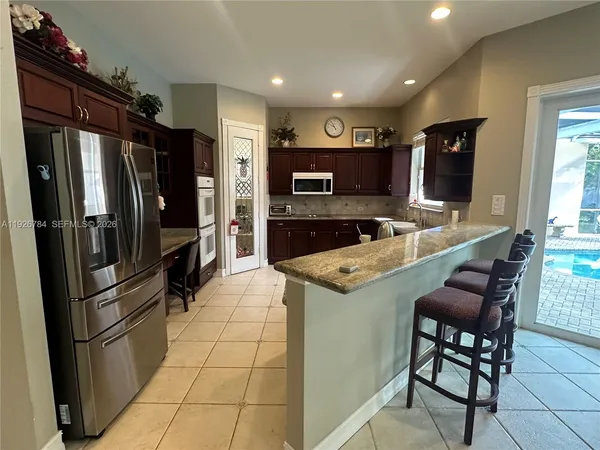 a kitchen with stainless steel appliances granite countertop a refrigerator and a stove top oven