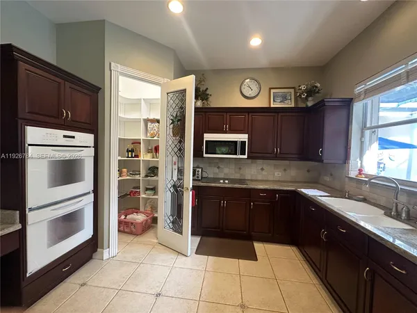 a kitchen with stainless steel appliances granite countertop a refrigerator and a sink