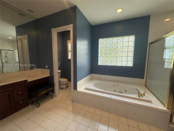 a spacious bathroom with a tub sink and mirror