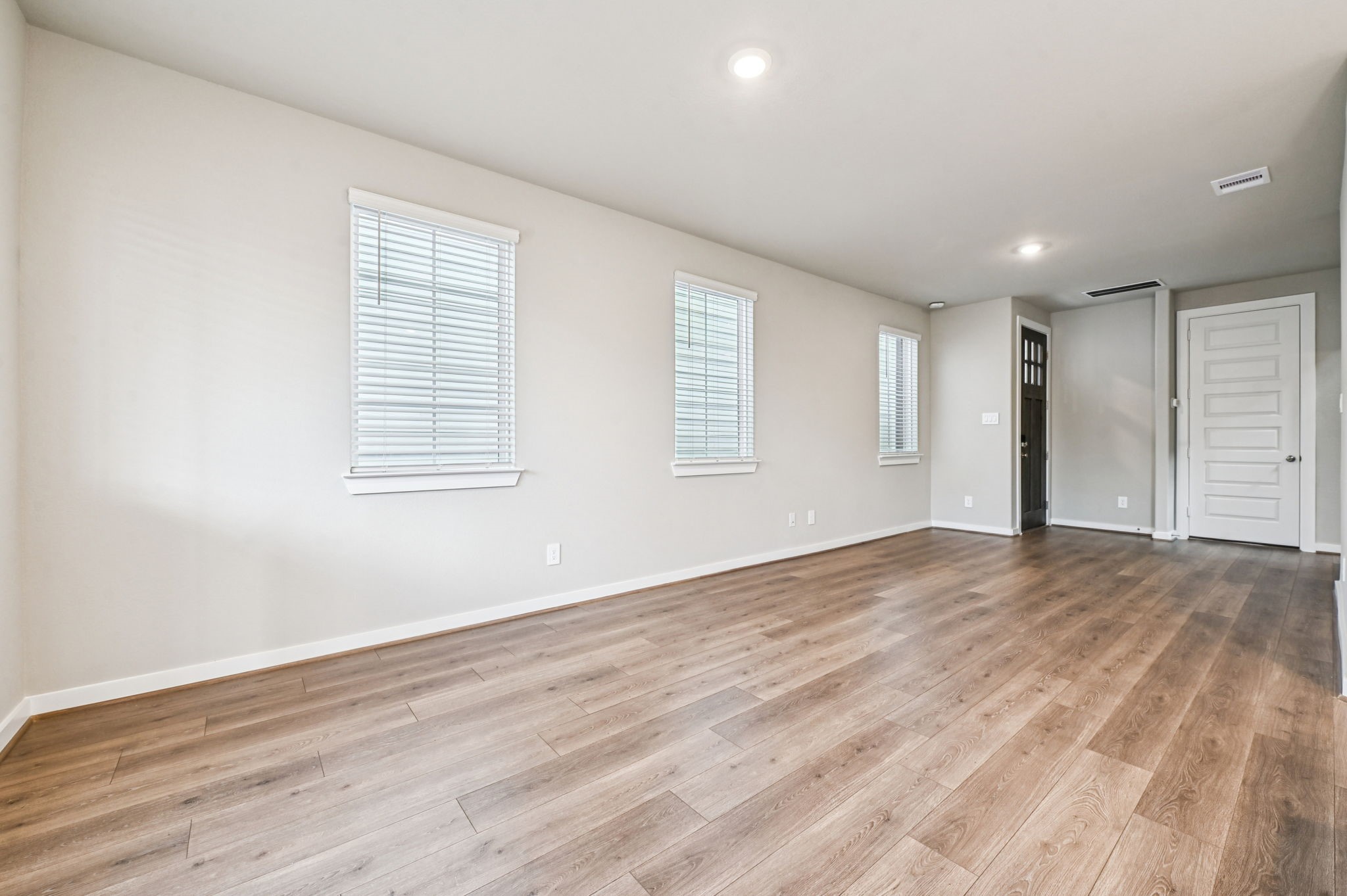 10008 Rustic Charm Street Houston, TX 77080 - Photo 4 of 30 an empty room with wooden floor and windows