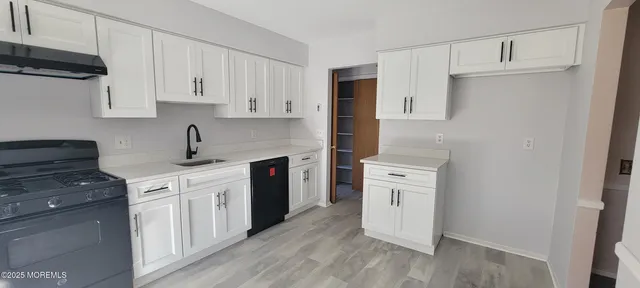a kitchen with white cabinets and white appliances