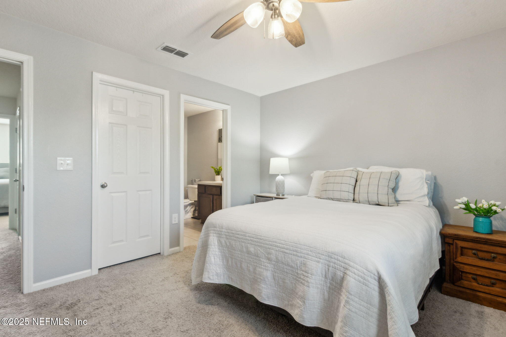 86440 Mainline Road Yulee, FL 32097 - Photo 15 of 36 a bedroom with a bed and a chandelier
