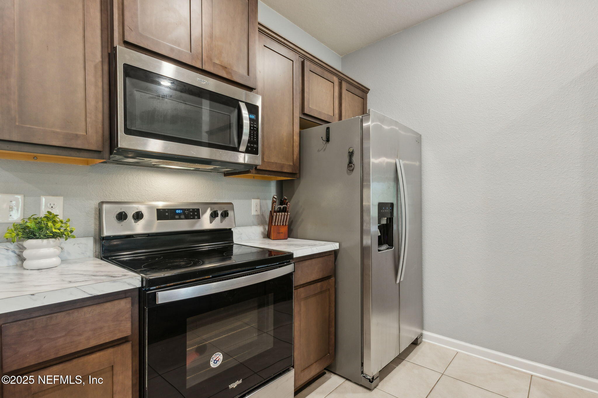 86440 Mainline Road Yulee, FL 32097 - Photo 10 of 36 a kitchen with stainless steel appliances a stove a microwave and cabinets