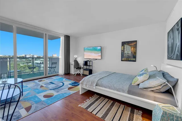 a bedroom with a bed and large windows