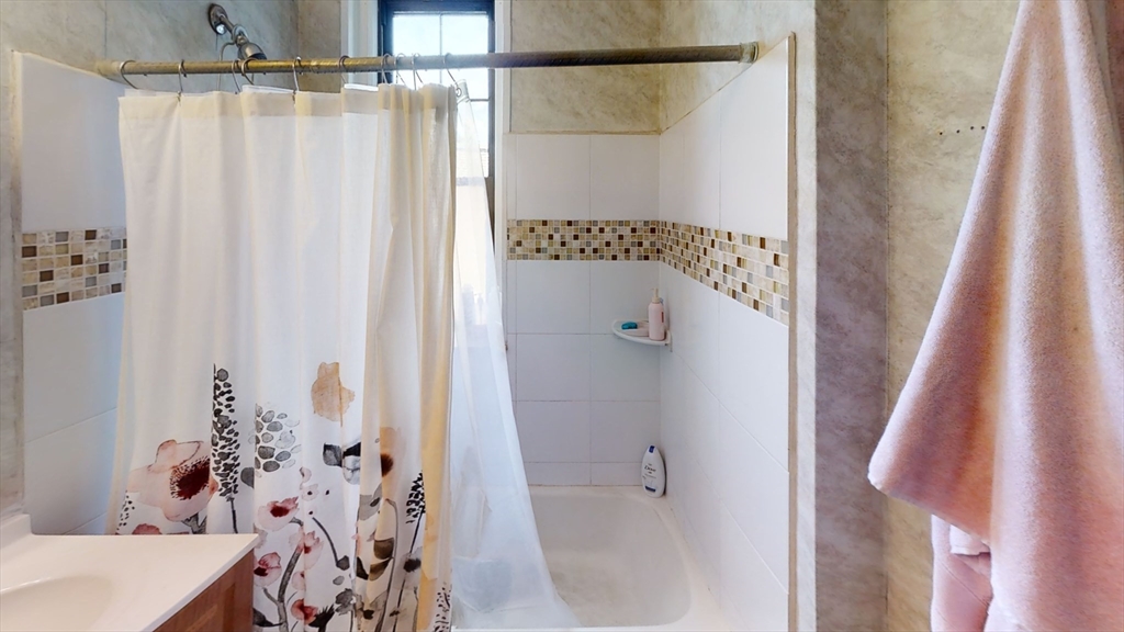6 Sutherland Road, Unit 41 Boston, MA 02135 - Photo 5 of 9 a bathroom with a shower curtain and a sink