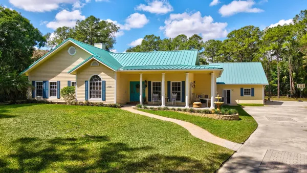 a view of a house with a yard and sitting area