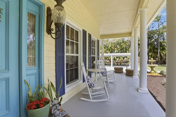 a patio with table and chairs and potted plants