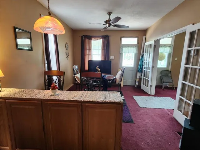 a living room with stainless steel appliances granite countertop furniture a fireplace and a chandelier