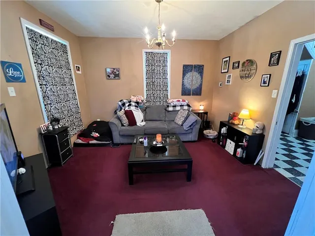 a living room with furniture floor to ceiling window and a flat screen tv