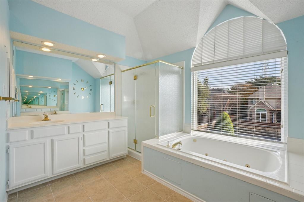 3110 Andrew Lane Carrollton, TX 75007 - Photo 26 of 36 a bathroom with a bathtub a double vanity sink and a shower