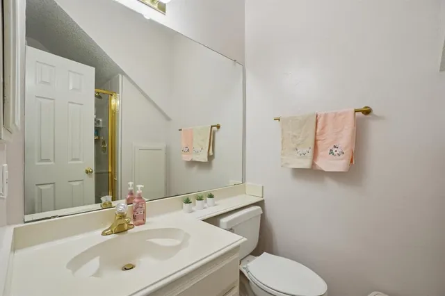 a bathroom with a toilet sink and mirror