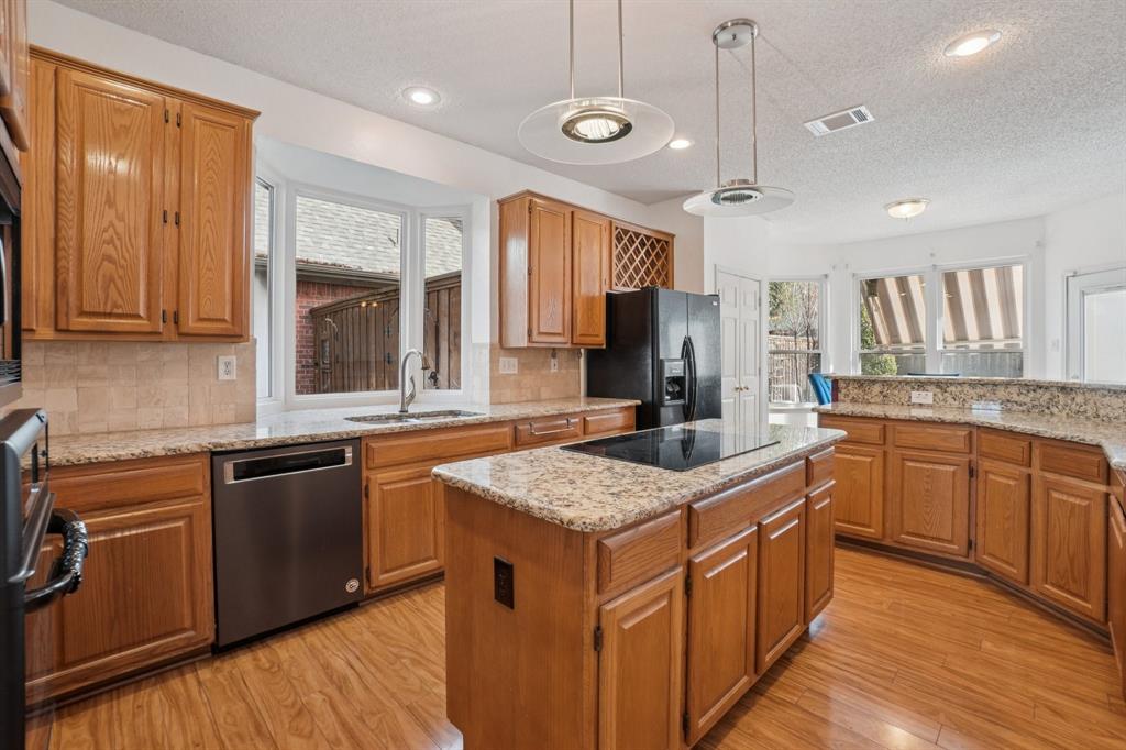3110 Andrew Lane Carrollton, TX 75007 - Photo 9 of 36 a kitchen with stainless steel appliances granite countertop a sink a stove and a wooden floors
