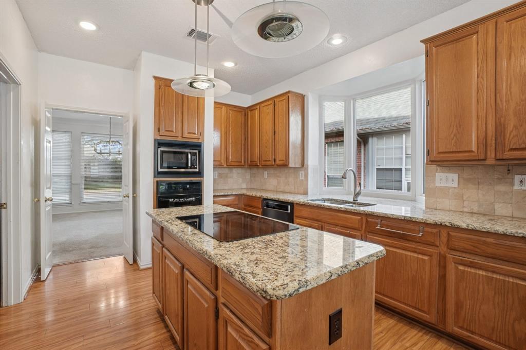 3110 Andrew Lane Carrollton, TX 75007 - Photo 10 of 36 a kitchen with kitchen island granite countertop a sink and refrigerator