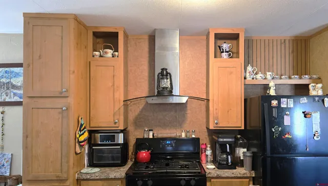 a kitchen with stainless steel appliances granite countertop a refrigerator and a stove