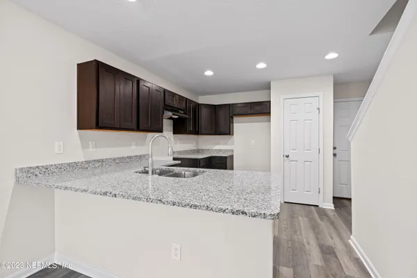 a kitchen with granite countertop kitchen island a sink stainless steel appliances and cabinets