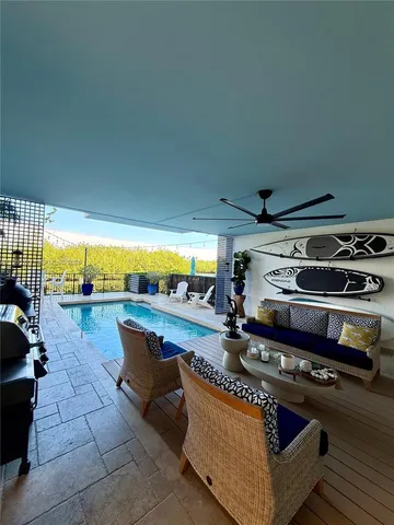 a living room with furniture a rug and a floor to ceiling window
