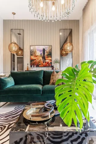 a living room with furniture a flat screen tv and kitchen view