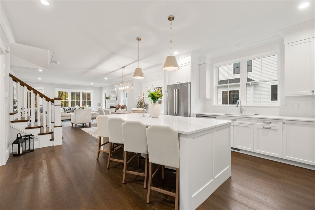 a large white kitchen with lots of counter space dining table and chairs