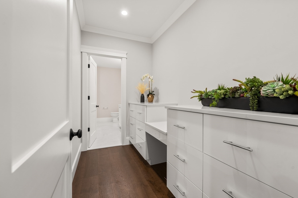 16 Wayside Road, Unit 14 Natick, MA 01760 - Photo 17 of 42 a hallway with white cabinets and potted plants
