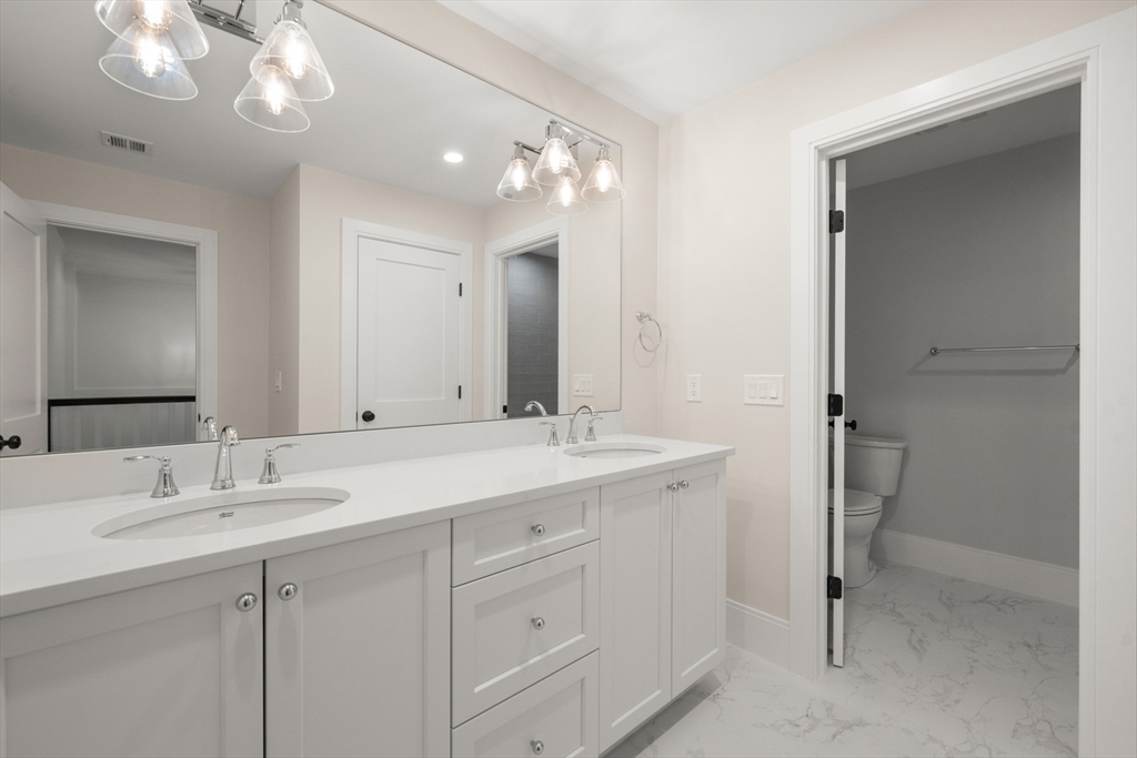 16 Wayside Road, Unit 14 Natick, MA 01760 - Photo 30 of 42 a bathroom with a double vanity sink and a mirror
