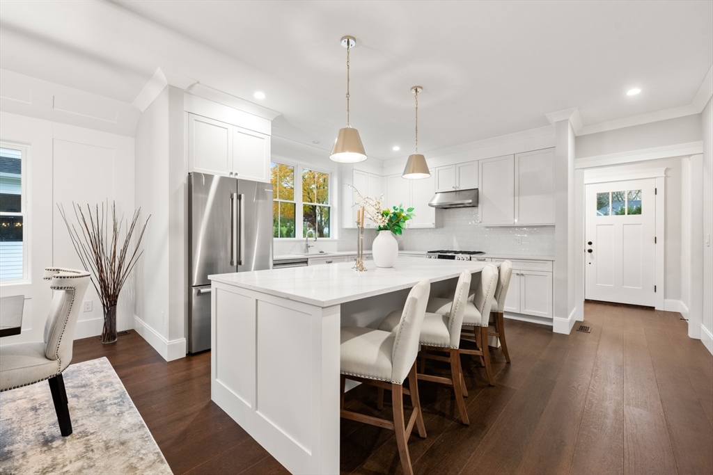 16 Wayside Road, Unit 14 Natick, MA 01760 - Photo 3 of 42 a kitchen with stainless steel appliances a dining table chairs stove refrigerator and cabinets