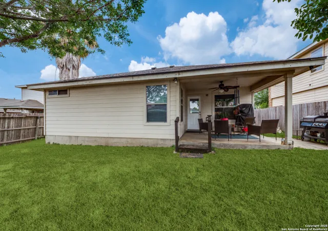 a view of a backyard with table and chairs and a large tree