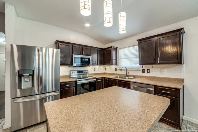 a kitchen with stainless steel appliances granite countertop a sink refrigerator and microwave