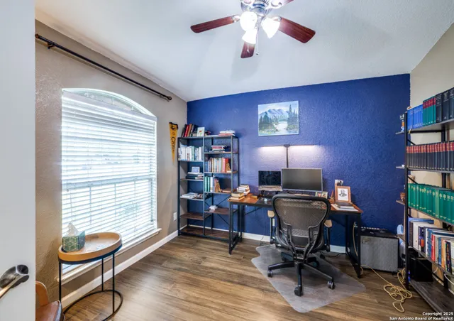 a view of a workspace with furniture and a window